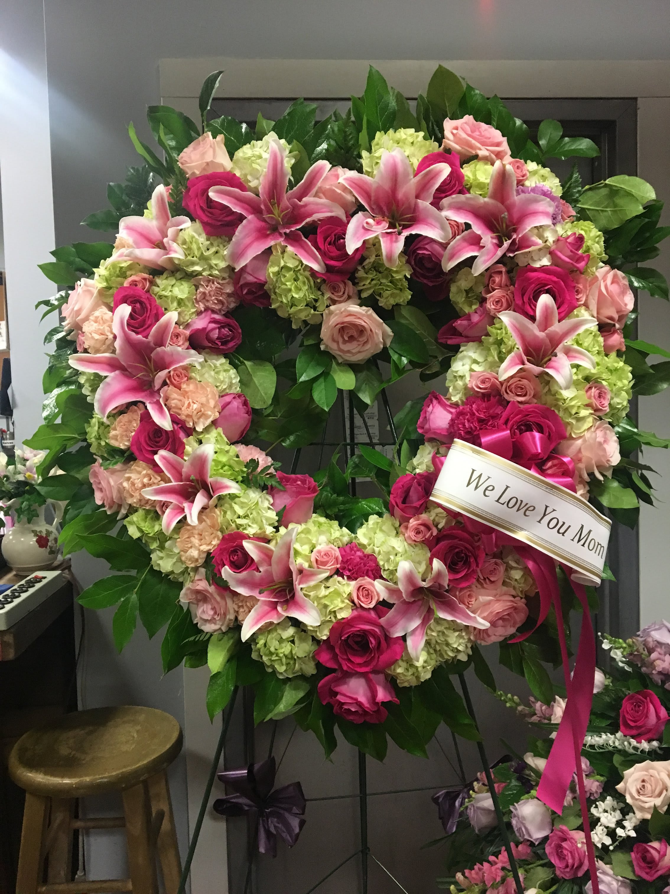 Heart-shaped floral wreath with pink lilies, roses, and hydrangeas