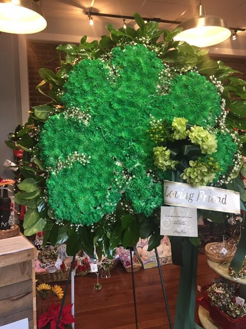 Large green floral standing spray with a "Loving Friend" ribbon