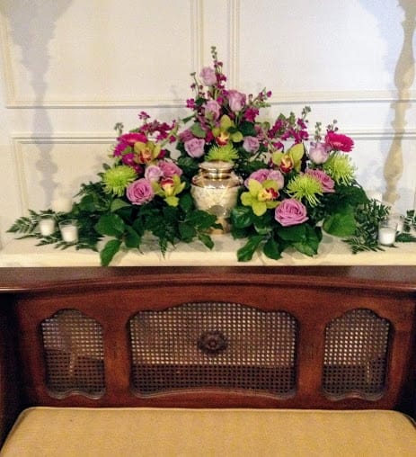 Pink and green floral arrangement with a gold urn centerpiece