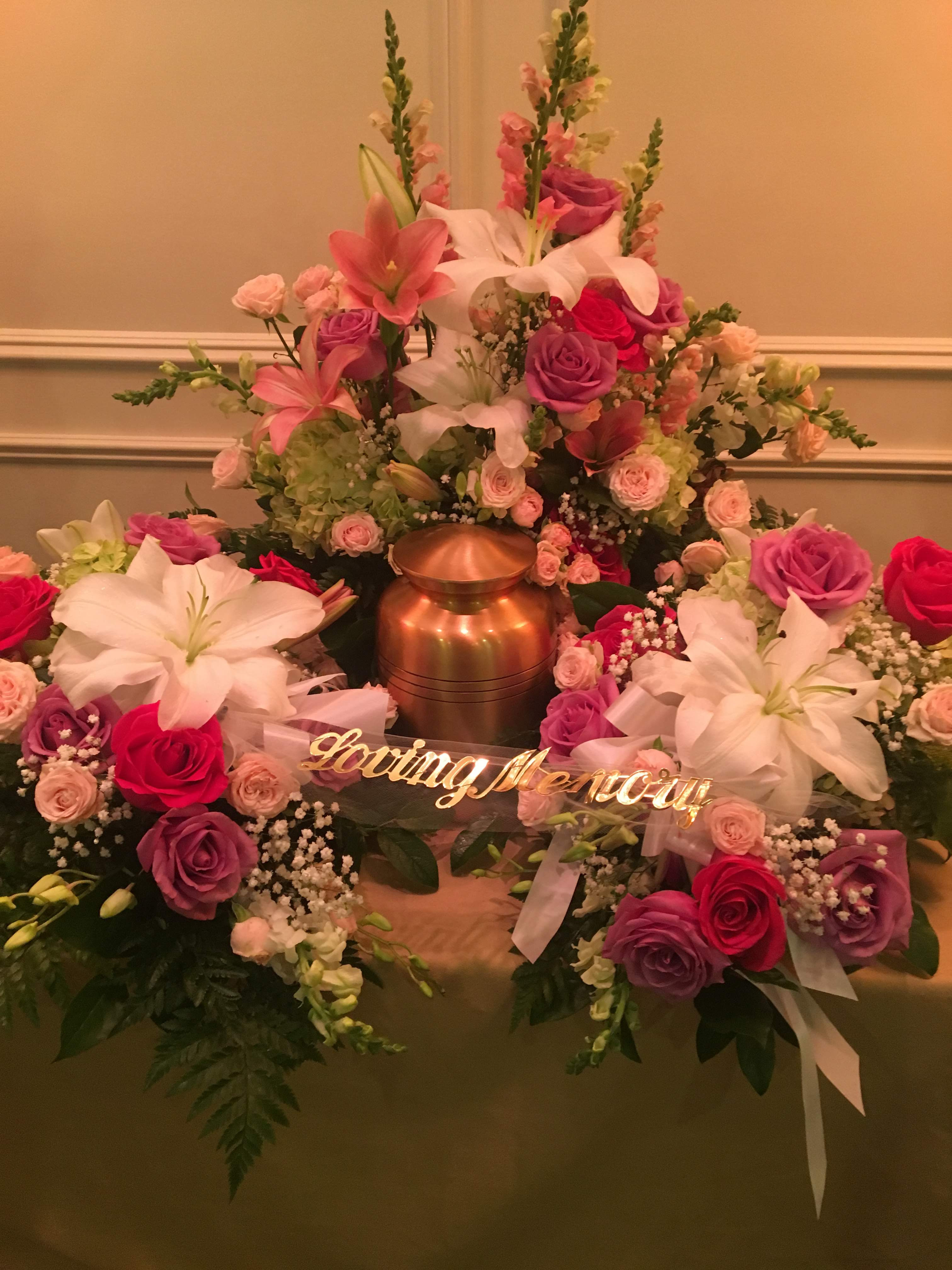 Large floral funeral arrangement with pink and white lilies and roses