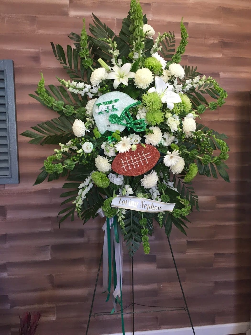 Football-themed standing floral spray with white and green flowers