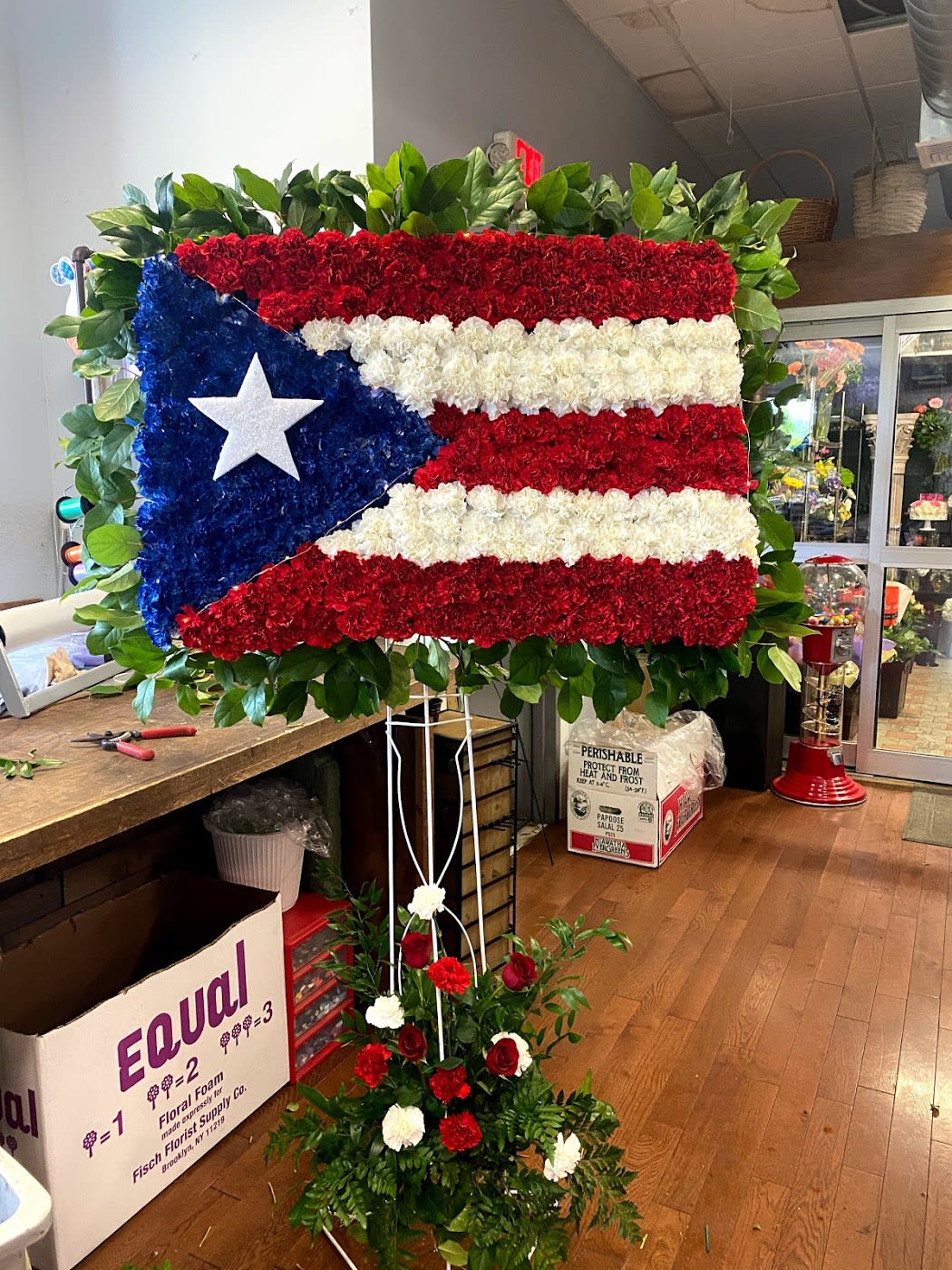 Large floral display shaped like the Puerto Rican flag on a stand