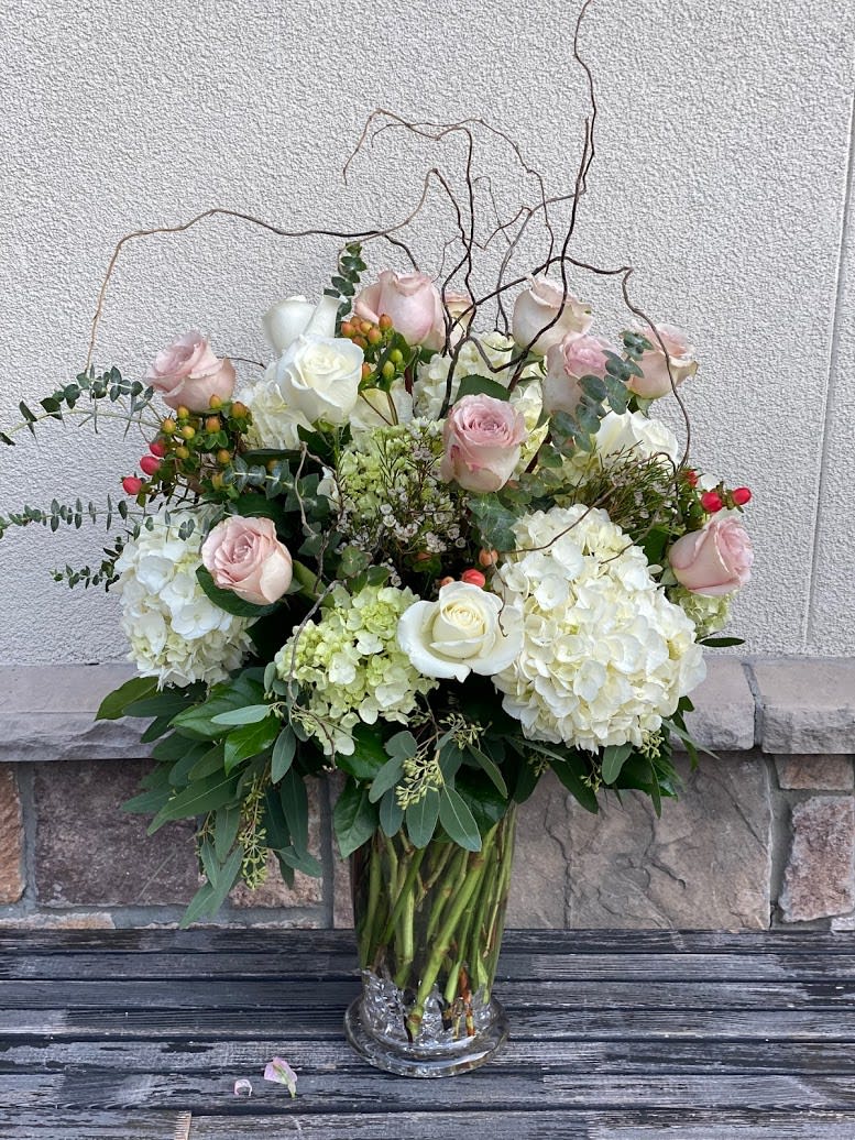 Bouquet of pale pink roses and white hydrangeas in a clear glass vase
