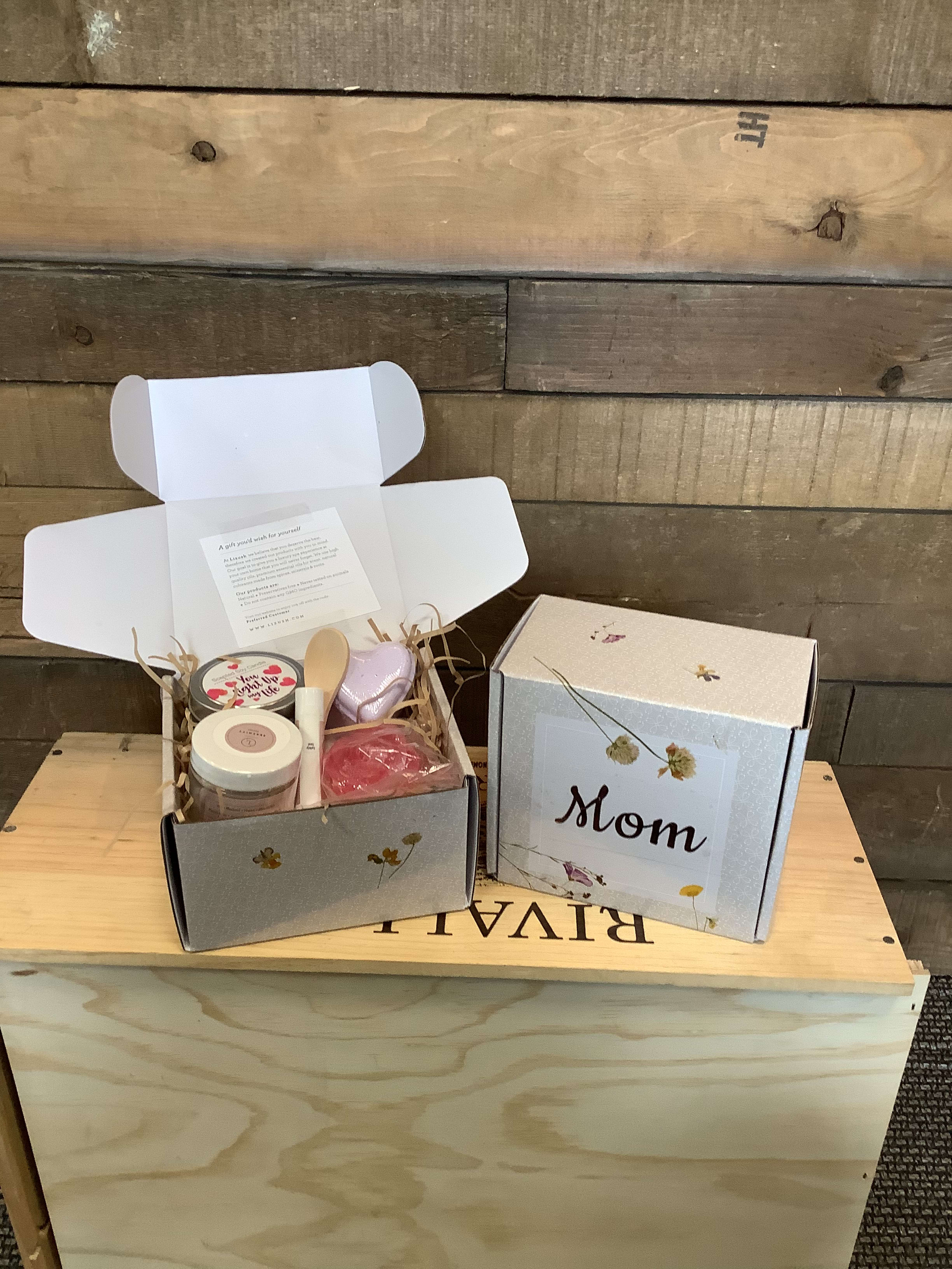Two open gift boxes with candles and bath items, one labeled Mom