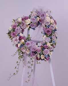 Shades of Purple Heart Easel Spray - When you want to send the very best, wear your heart on your sleeve. Send this beautiful heart wreath to the service of your loved one. Shown here in purple, this wreath can be customized to the colors of your choice. (If you wish to order this in custom colors, please call in your order.)