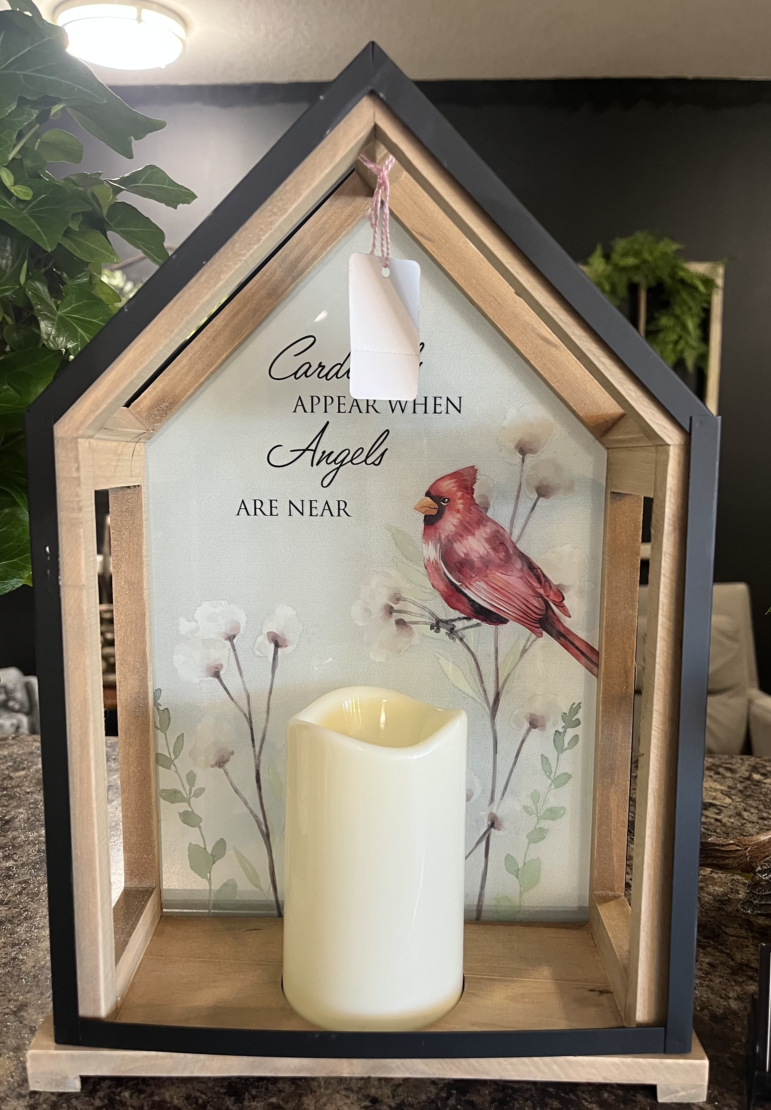 House-shaped memorial lantern with a candle and cardinal artwork