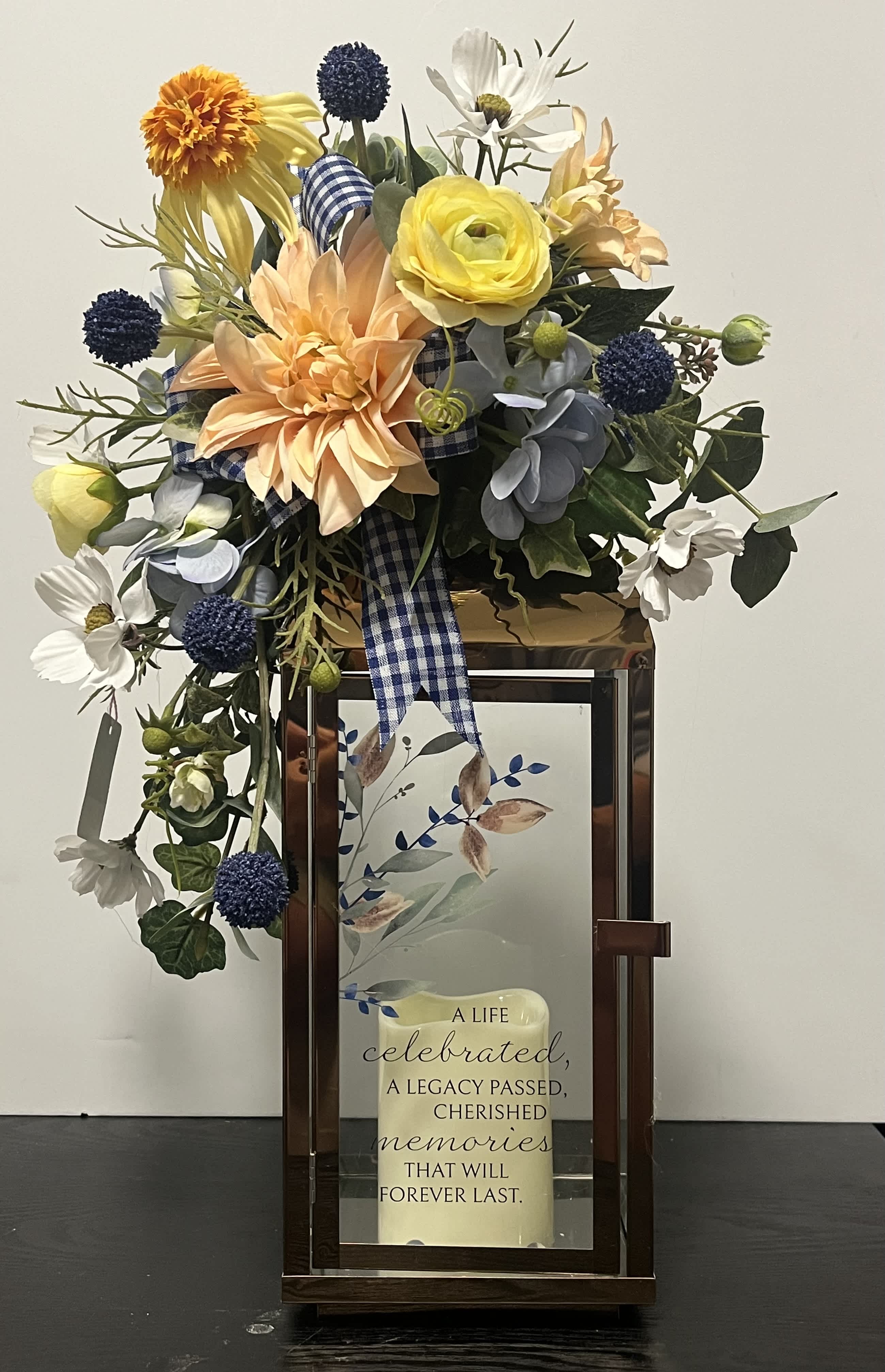 Mixed floral arrangement in a lantern-style frame with a memorial plaque