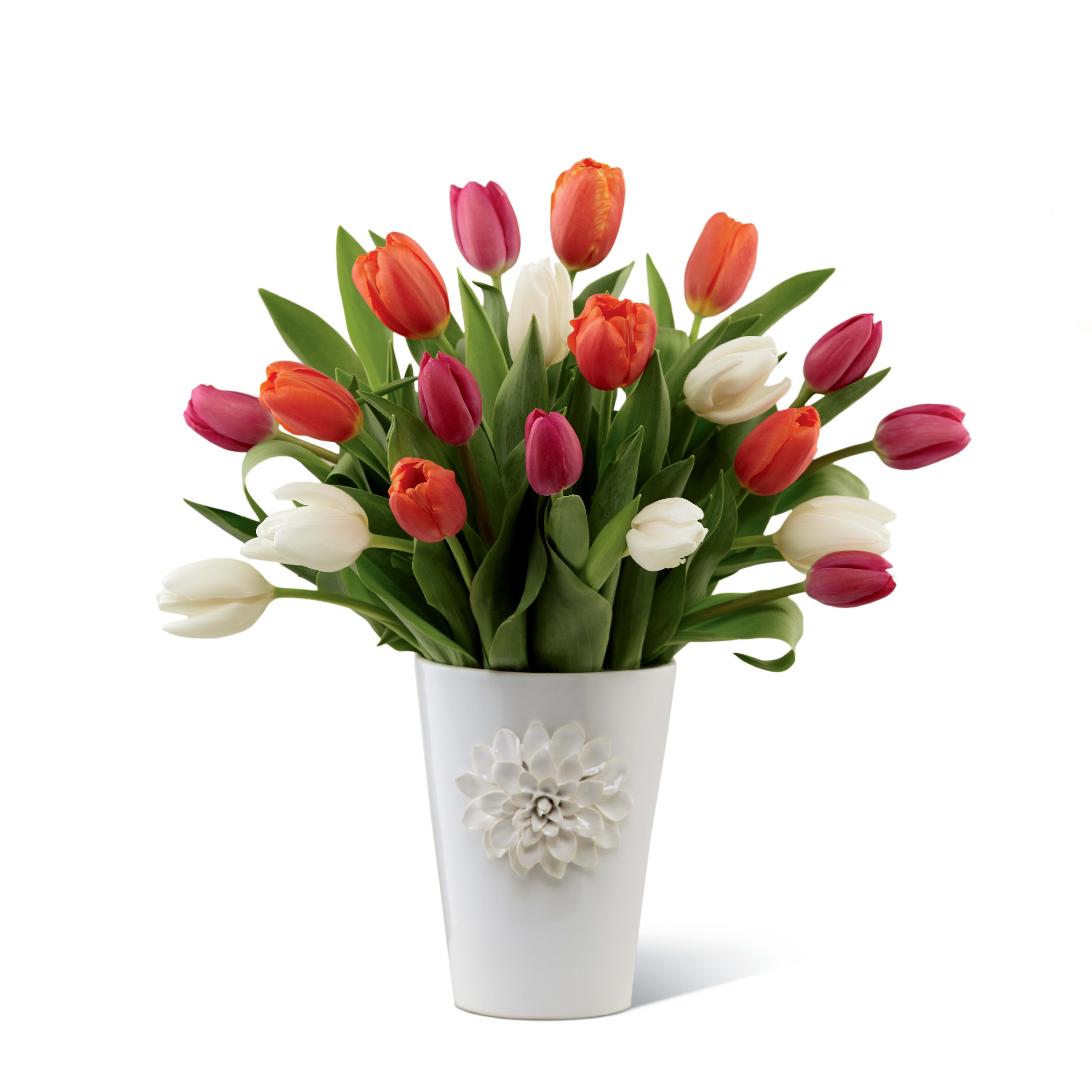 The FTD® Pacific Trends™ Bouquet for Kathy Ireland Home - Item Number: K01s  The FTD® Pacific Trends Bouquet for Kathy Ireland Home brings the famed designer’s exuberant joie de vivre to any occasion and beautifully hits the spot when it comes to making any day special. Simple, yet sizzling with on-trend sophistication, it almost glows with a painterly mix of tulips in tranquil white, spicy orange and sweet hot pink accented with lush greens. Beautifully arranged in a white ceramic vase blooming with a hand sculpted blossom, it gorgeously evokes an ocean sunset to color any day, “sensational!