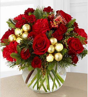 The FTD® Holiday Gold™ Bouquet - The FTD® Holiday Gold™ Bouquet blooms with the magic of the Christmas season to send your warmest season's greetings to your special recipient. Rich red roses, burgundy mini carnations, red carnations and an assortment of lush holiday greens are arranged to perfection to create an incredible flower bouquet. Accented with shining gold glass ball pics and clusters of Christmas present pics beautifully presented in a clear glass bubble bowl vase, this regal holiday flower arrangement will make a fantastic gift or centerpiece for their holiday table. This bouquet is approximately 11"H x 12"W Your purchase includes a complimentary personalized gift message.