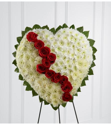 Heart-shaped white floral wreath with a diagonal line of red roses