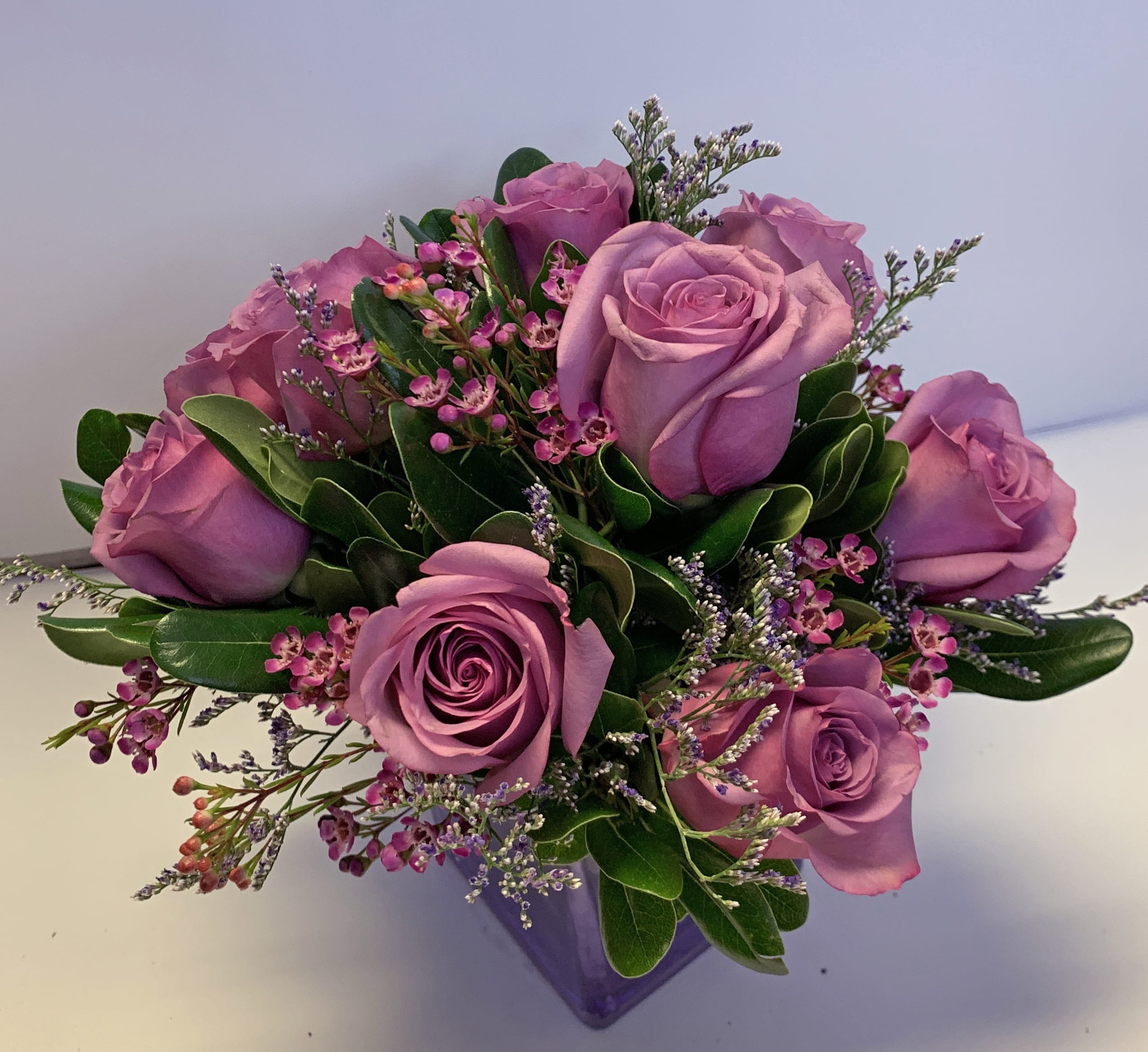 Teleflora's Morning Melody - Shades of purple are in perfect harmony in this profoundly pretty arrangement. A lovely mix of classic and modern, ribbons and roses, it's sure to make someone's day!  Lavender roses and waxflower, purple limonium and greens are hand-delivered in a lavender cube that's all wrapped up with a vibrant purple taffeta ribbon.  Approximately 10 1/2" W x 11" H  Orientation: One-Sided  Regular : T68-3A As shown Deluxe : T68-3B Premium : T68-3C