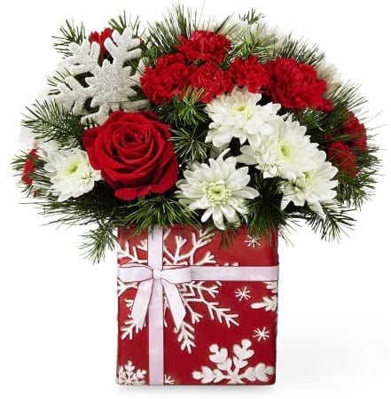 Red and white flowers in a gift box with a white ribbon