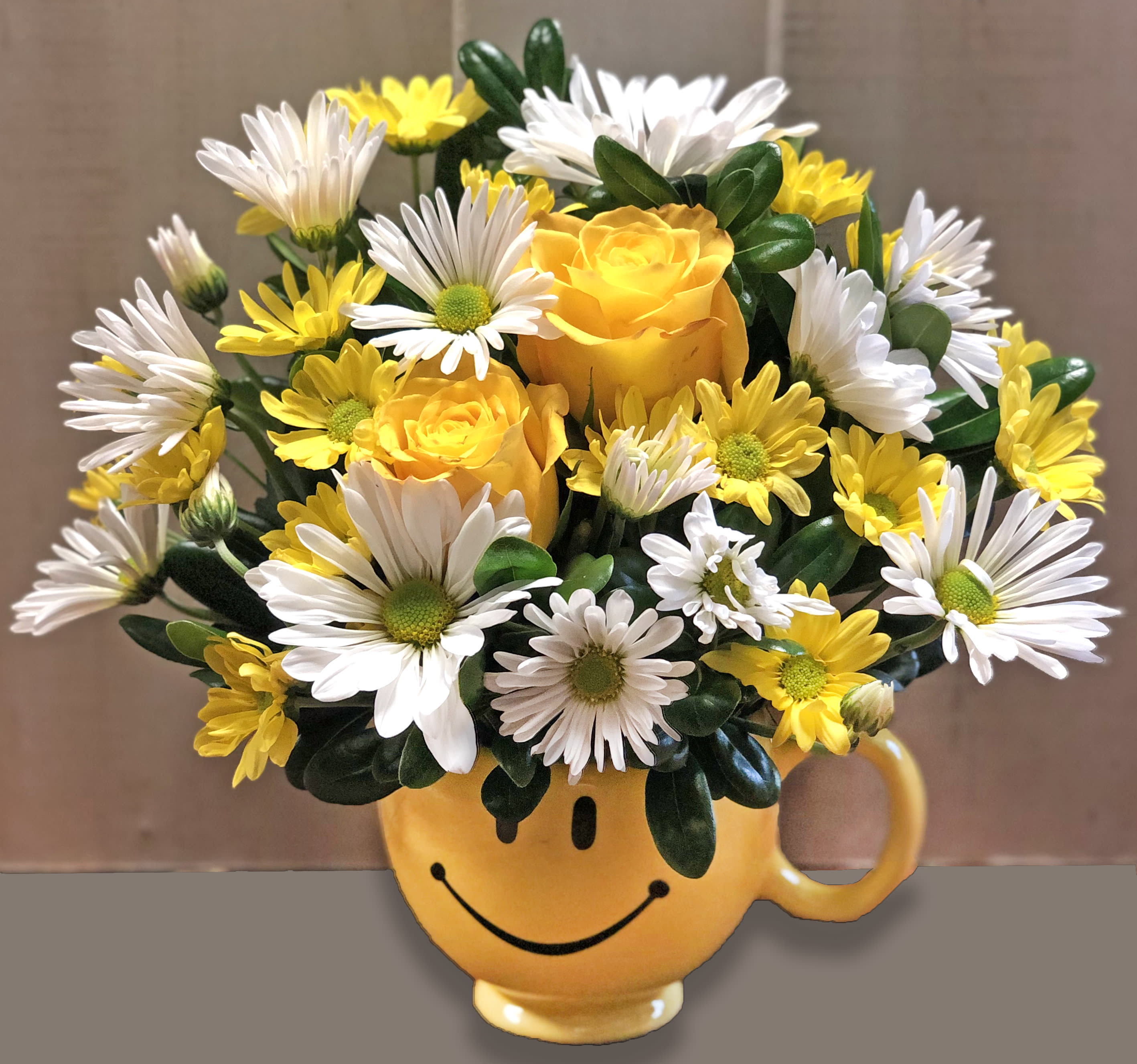 Yellow and white flower bouquet in a smiley-face mug