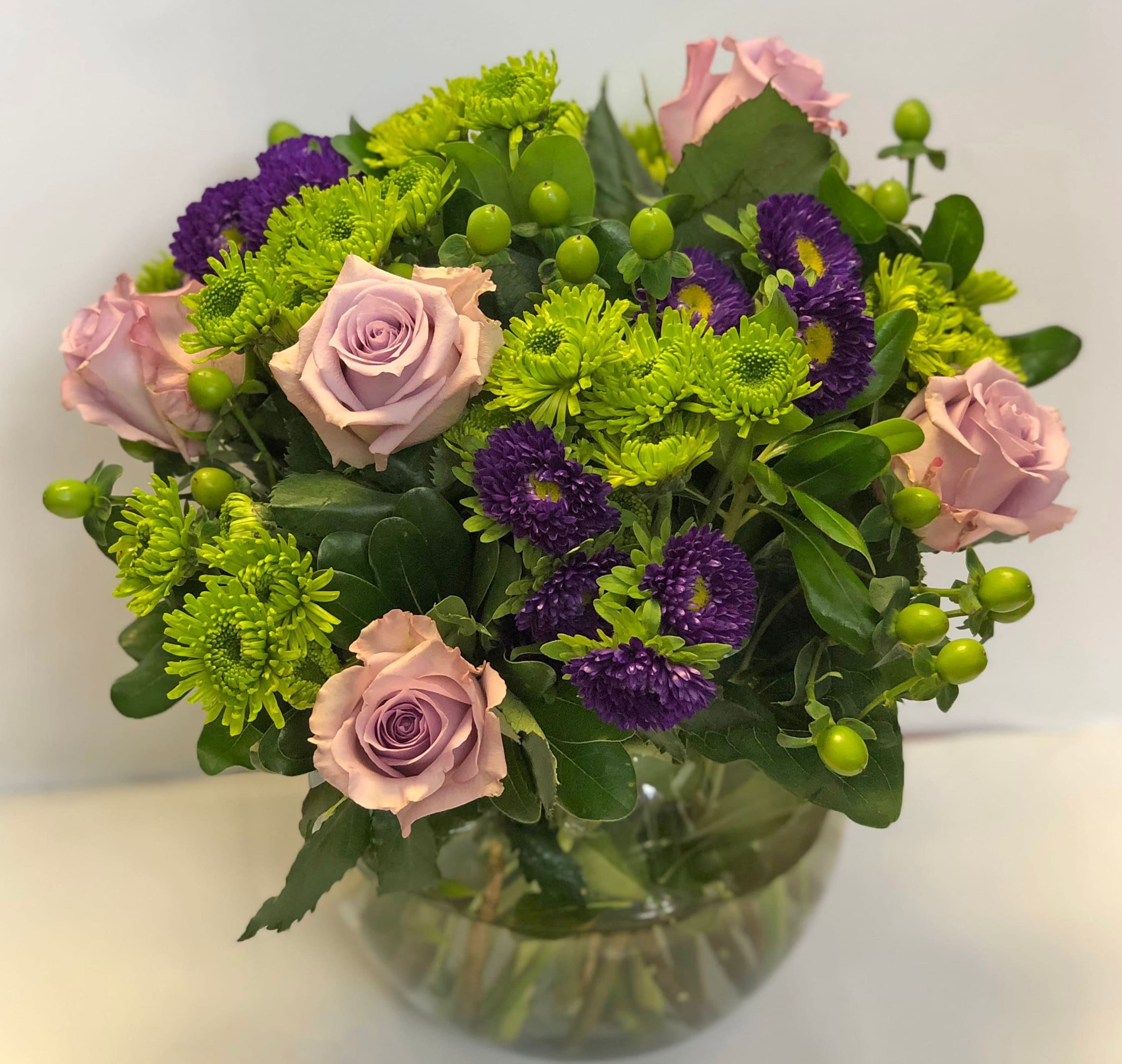 The FTD A Splendid Day Bouquet - The FTD A Splendid Day Bouquet, set with roses and asters, creates the perfect bouquet for any of life's special moments. Lavender roses, lavender monte casino asters, purple matsumoto asters, green hypericum berries, green button poms and lush greens create a stunning flower bouquet perfectly arranged in a clear glass bubble bowl vase to create a wonderful thank you, happy birthday or congratulations gift. GOOD bouquet includes 13 stems. Approx. 10âH x 12âW. BETTER bouquet includes 18 stems. Approx. 13âH x 14âW. BEST bouquet includes 23 stems. Approx. 14âH x 15âW. DELUXE SIZE PICTURED