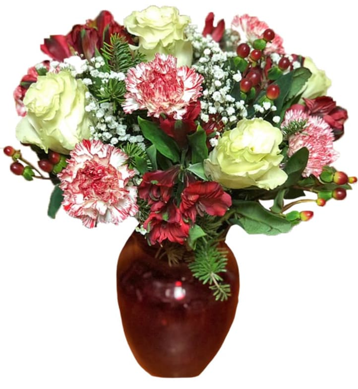 The FTD® Holiday Brights Bouquet by Better Homes and Gardens® - Picked fresh from the farm to bring color and beauty to your special recipient's holiday season, the Better Homes and Gardens® Holiday Brights Bouquet is at it's blooming best to make this yuletide one they won't soon forget. Hand gathered at select floral farms and showcasing deep reds and greens with pops of jade green to add to the festivity of the overall look and style, this gorgeous bouquet has been picked fresh for you to create that perfect Christmas gift. Bouquet includes: jade green roses, red carnations, peppermint carnations, red and white bi-colored Peruvian Lilies, red hypericum berries, and lush holiday greens. Presented with a red glass posy jar vase. IMAGE SHOWN IS DELUXE SIZE Your purchase includes a complimentary personalized gift message.