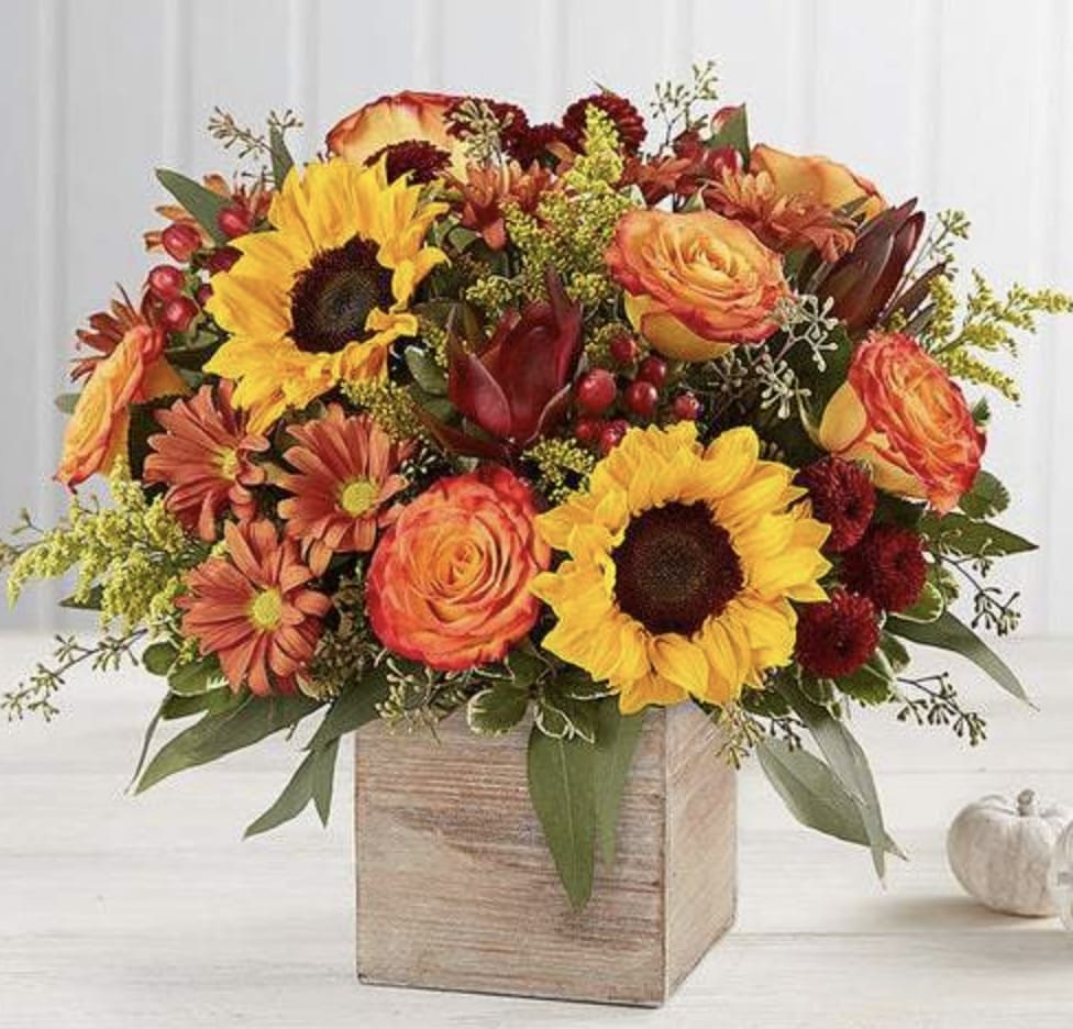 Autumn floral arrangement with sunflowers, roses, and mums in a wooden box