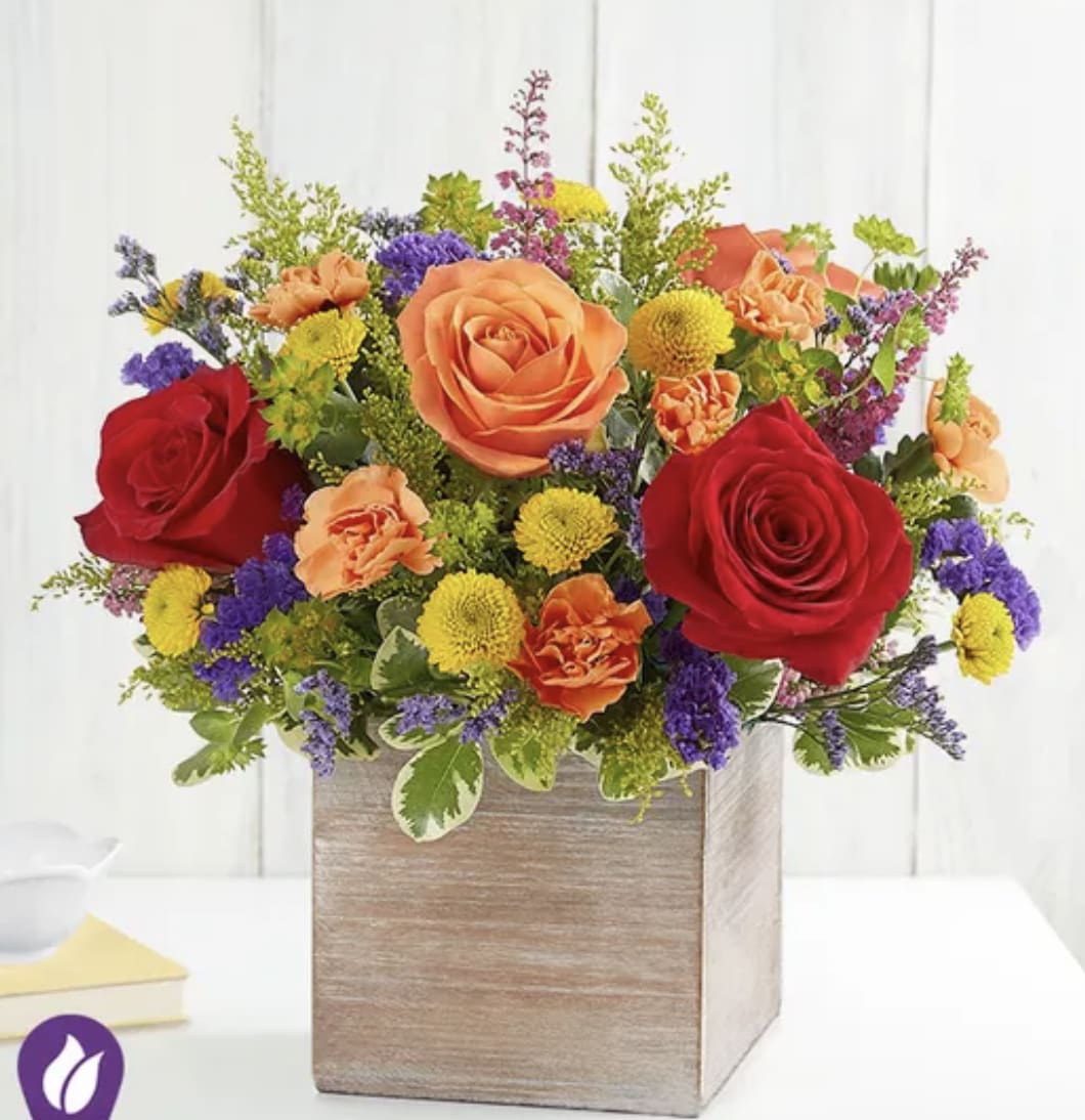 Mixed bouquet of roses, carnations, and button mums in a wooden box