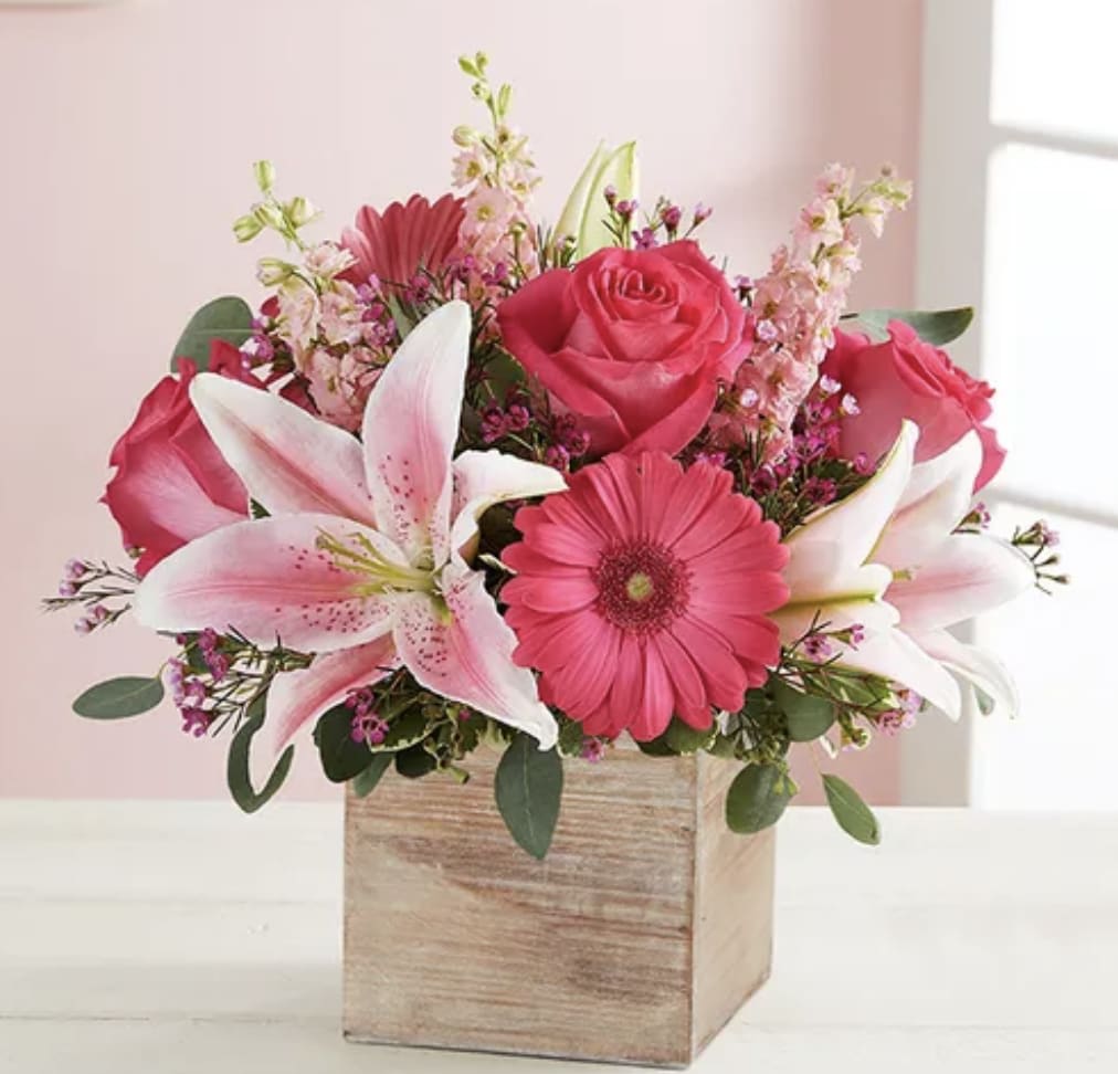 Pink roses, lilies, and gerbera daisies in a wooden box