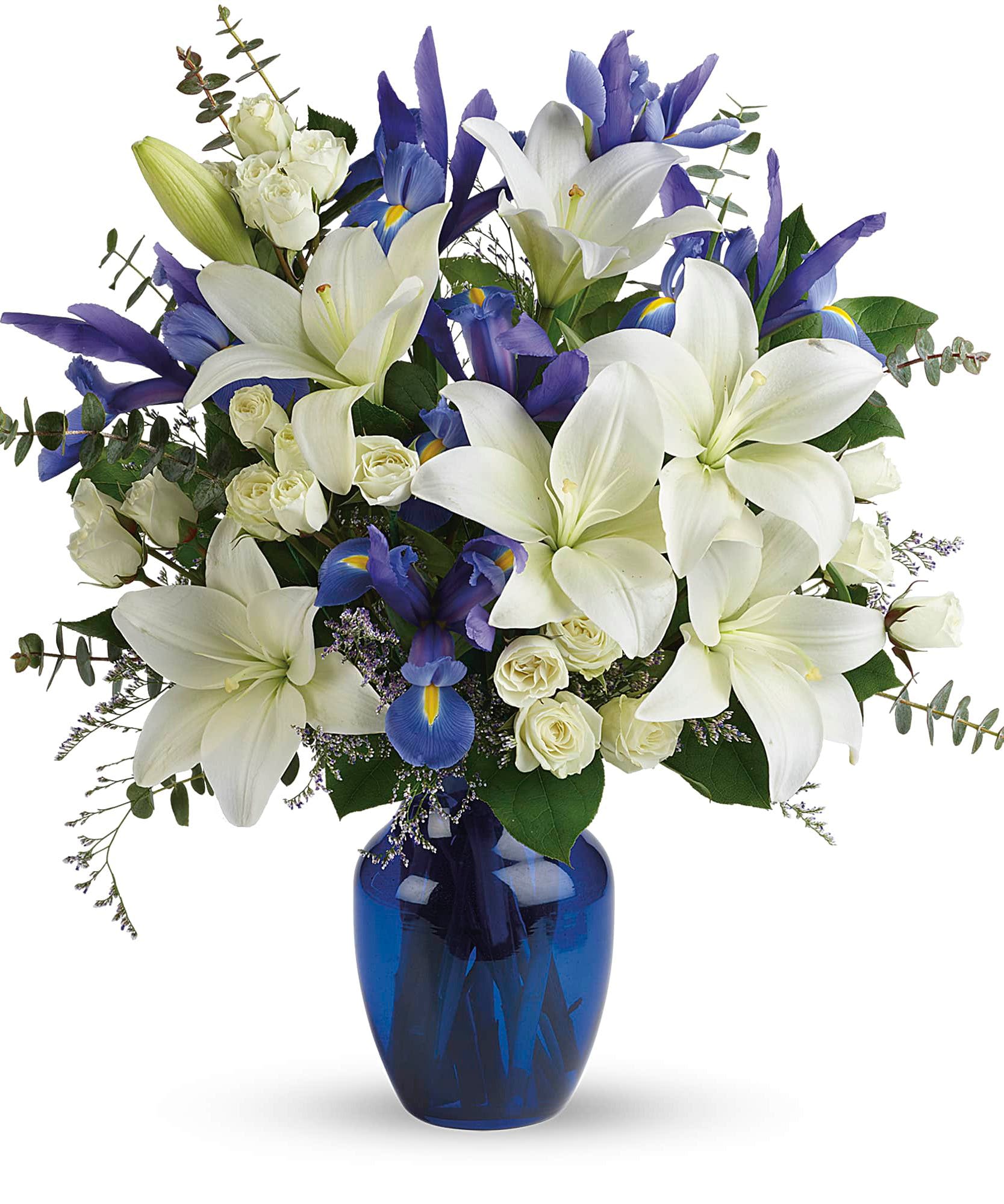 White lilies and blue irises in a blue glass vase