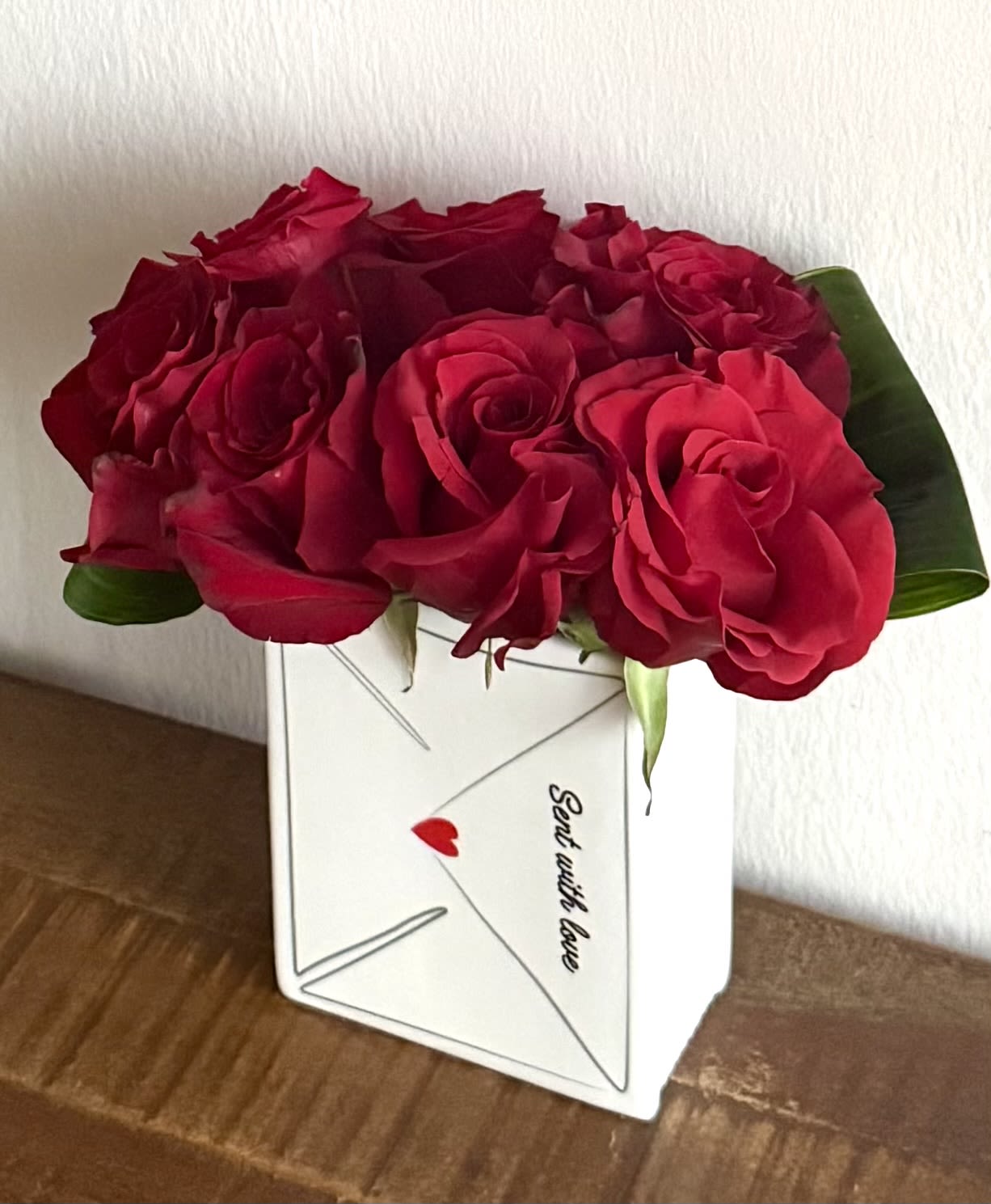 Red roses arranged in a white envelope-shaped box