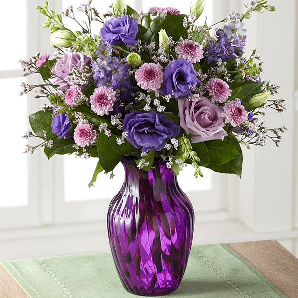 Purple and pink mixed bouquet in a purple glass vase