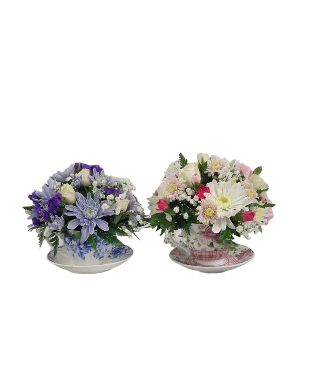 Two mixed flower arrangements in teacups on saucers