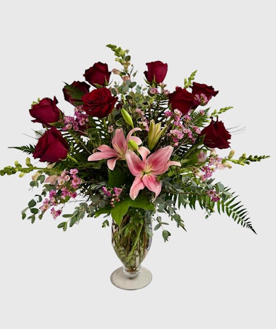 Bouquet of red roses and pink lilies in a glass vase