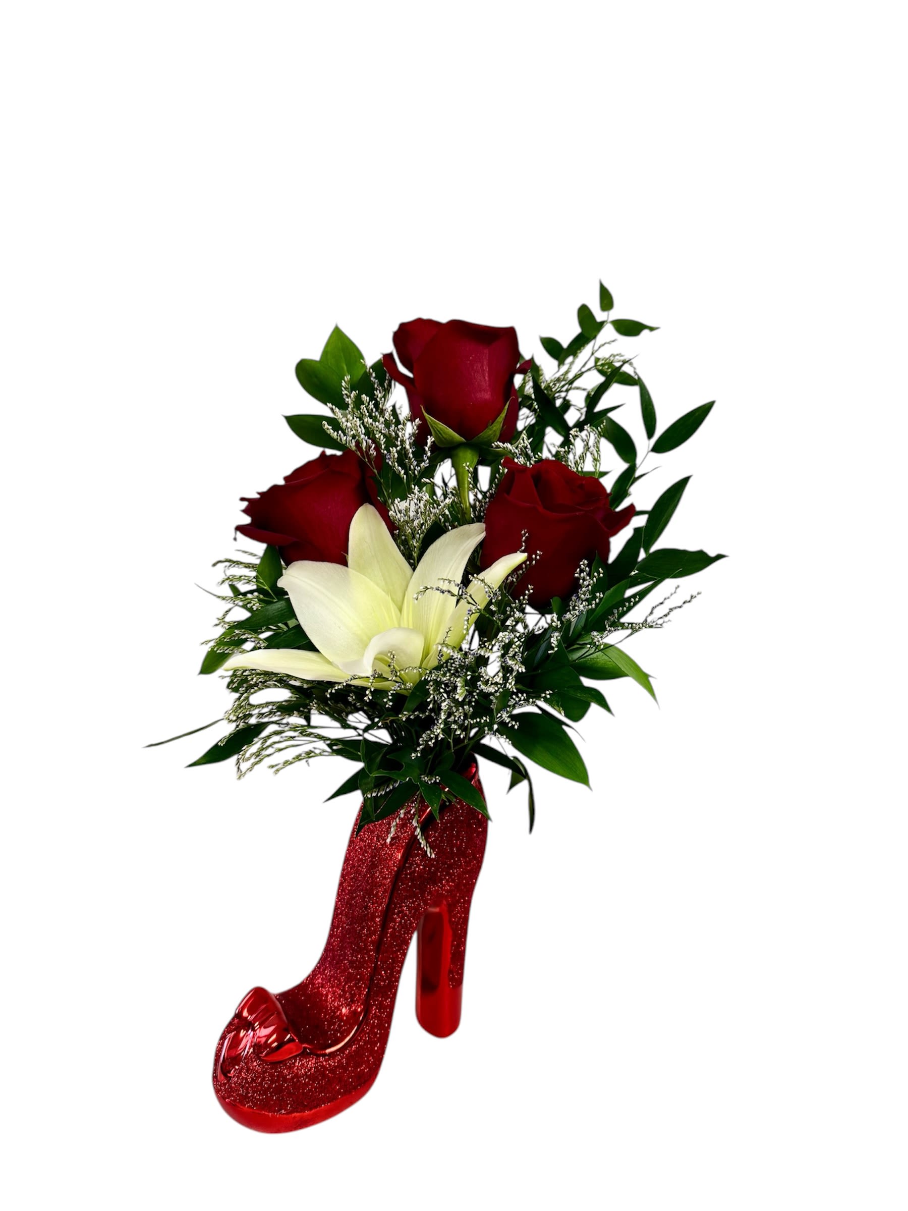 Red roses and a white lily arranged in a glittery red high-heel vase