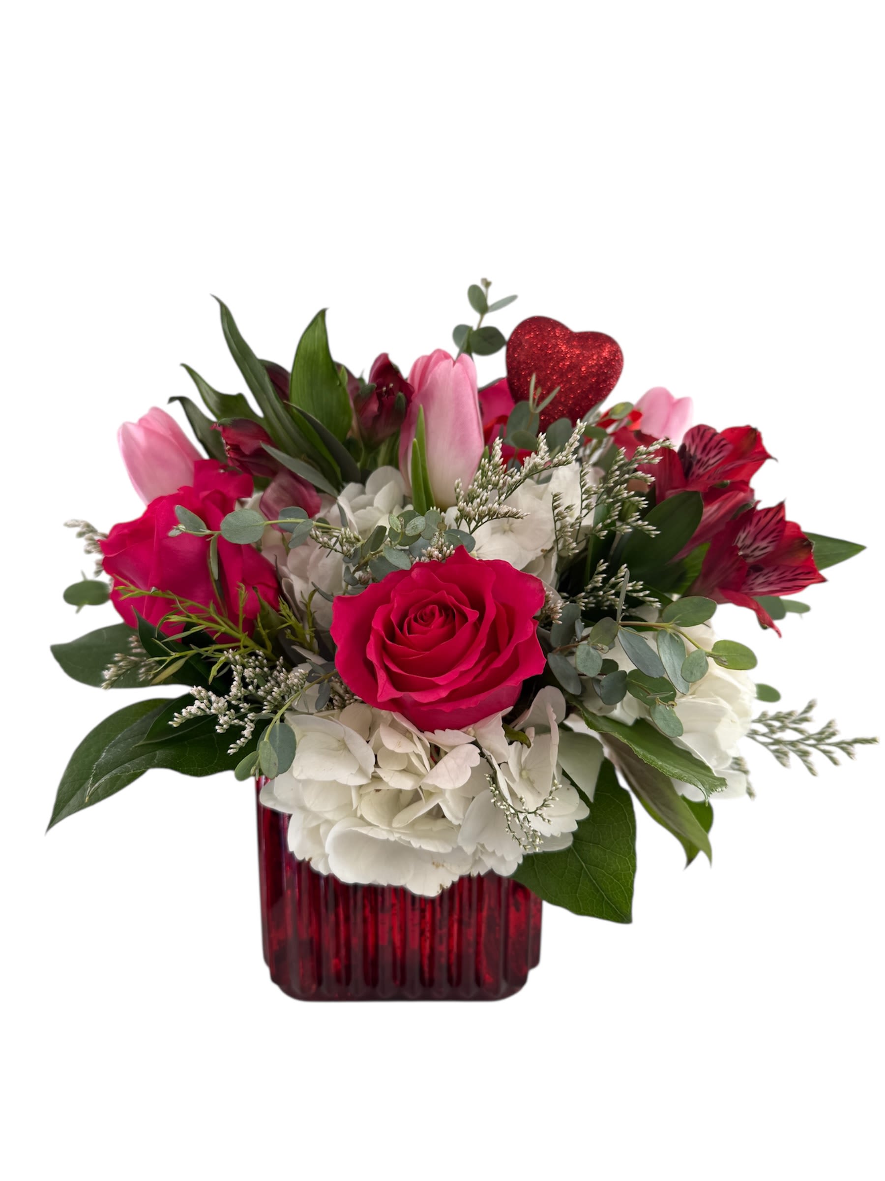 Pink and white flower arrangement in a red vase with a glitter heart pick