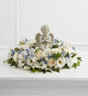 White floral arrangement with an angel figurine centerpiece