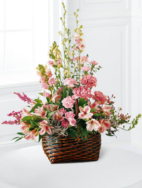 Pink mixed flower arrangement in a woven basket