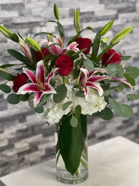 Love Spell  -  A Beautiful tower of Stargazer lilies, Red roses, hydrangea with a modern twist. 