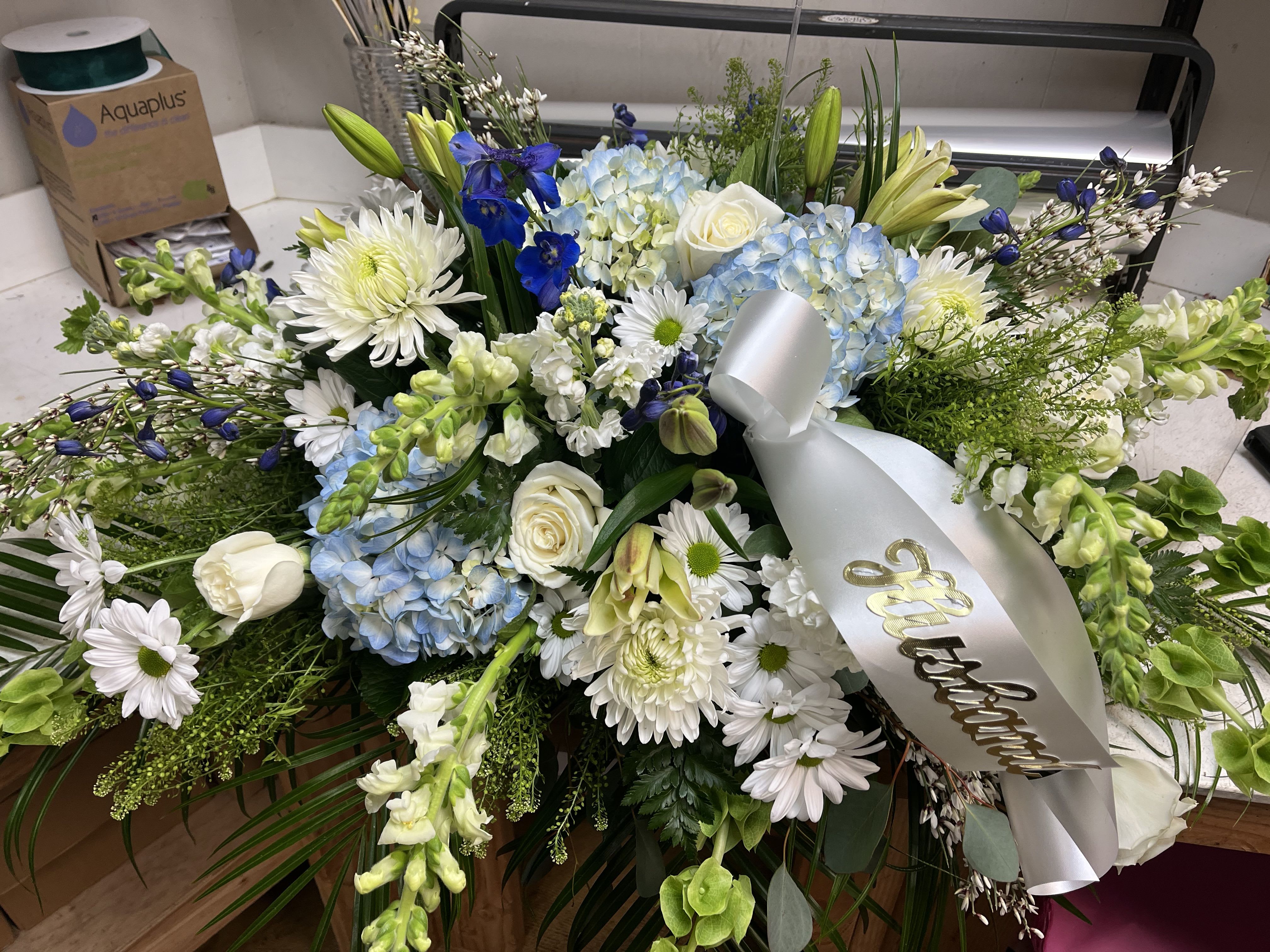 Large white and blue floral spray with a silver ribbon