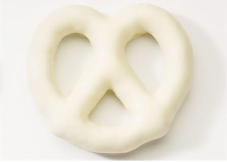 White pretzel-shaped snack on a plain background