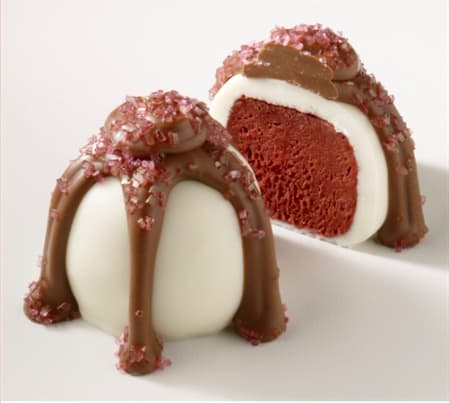 Two chocolate-dipped cake truffles with pink sugar crystals