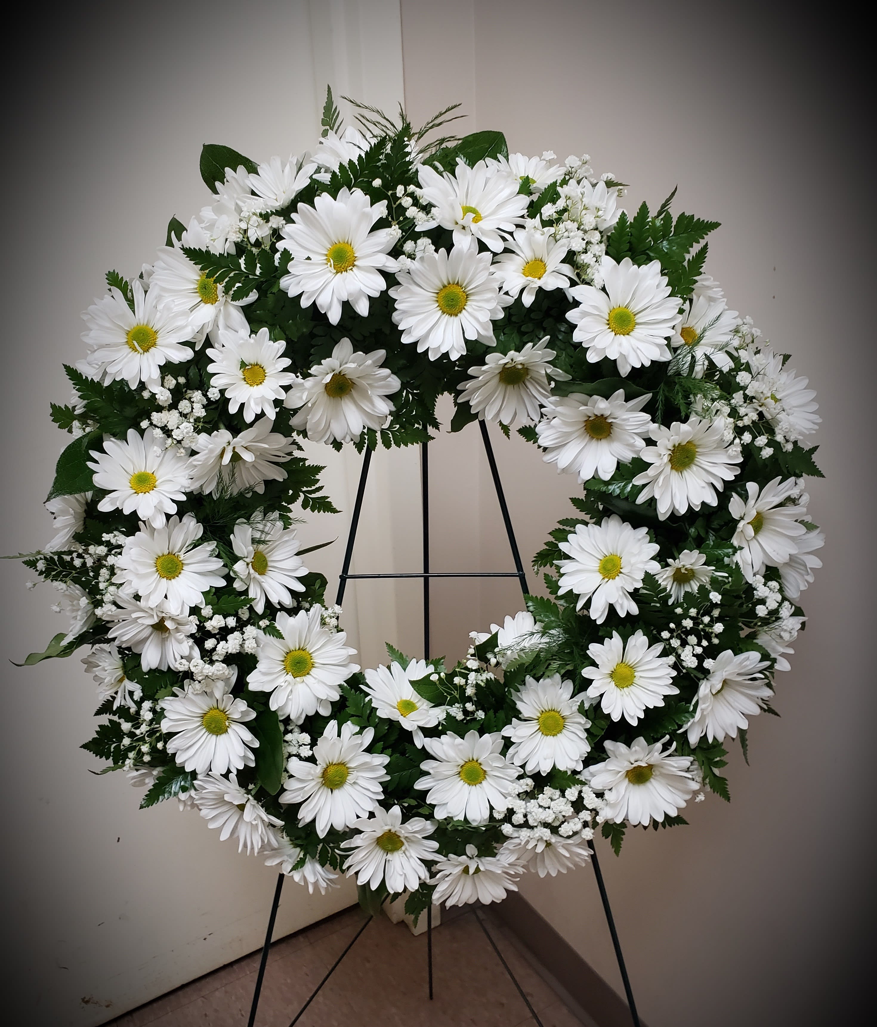 White daisy wreath on a black stand