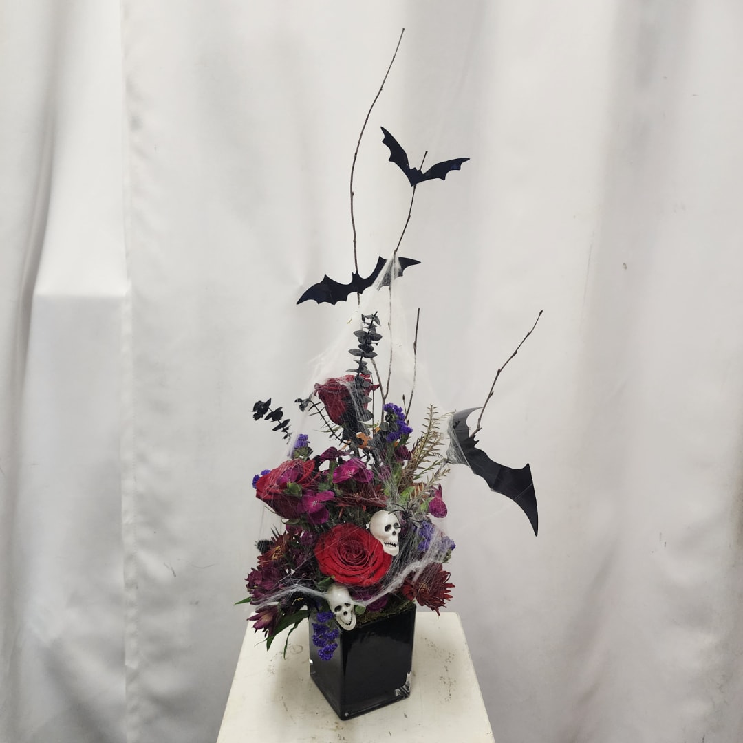 Halloween floral arrangement with red and purple flowers in a black vase