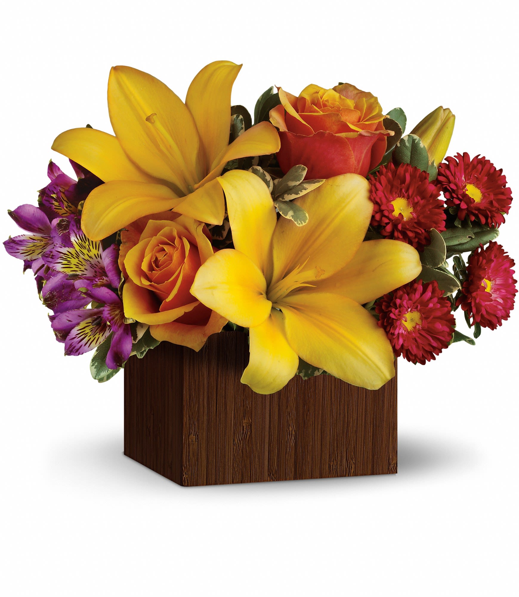 Compact arrangement of yellow lilies, orange roses, and red and purple blooms in a brown cube vase