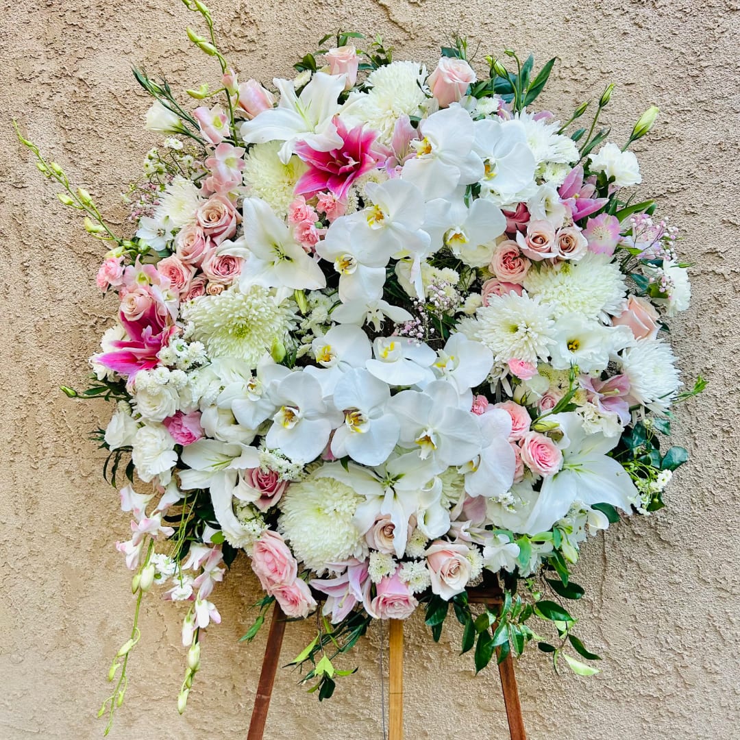 Large white and pink floral standing arrangement on an easel