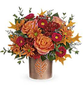 Autumn bouquet of orange roses and magenta mums in a bronze vase