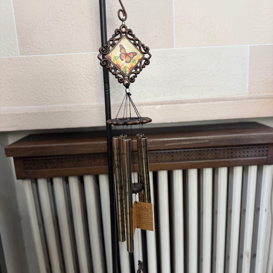 Decorative butterfly wind chime with metal tubes hanging indoors
