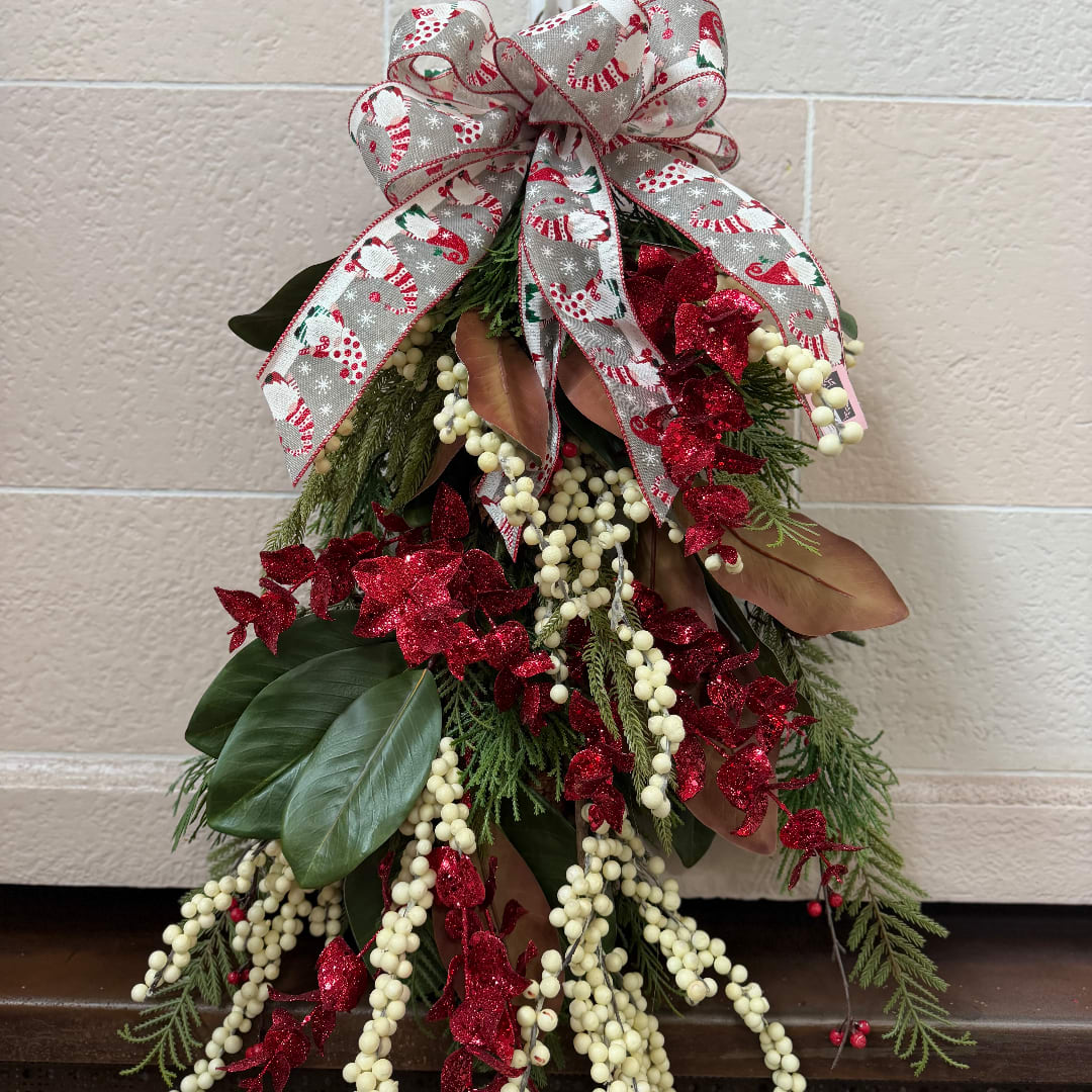 Holiday swag with a large plaid bow, red glitter accents, and white berry strands