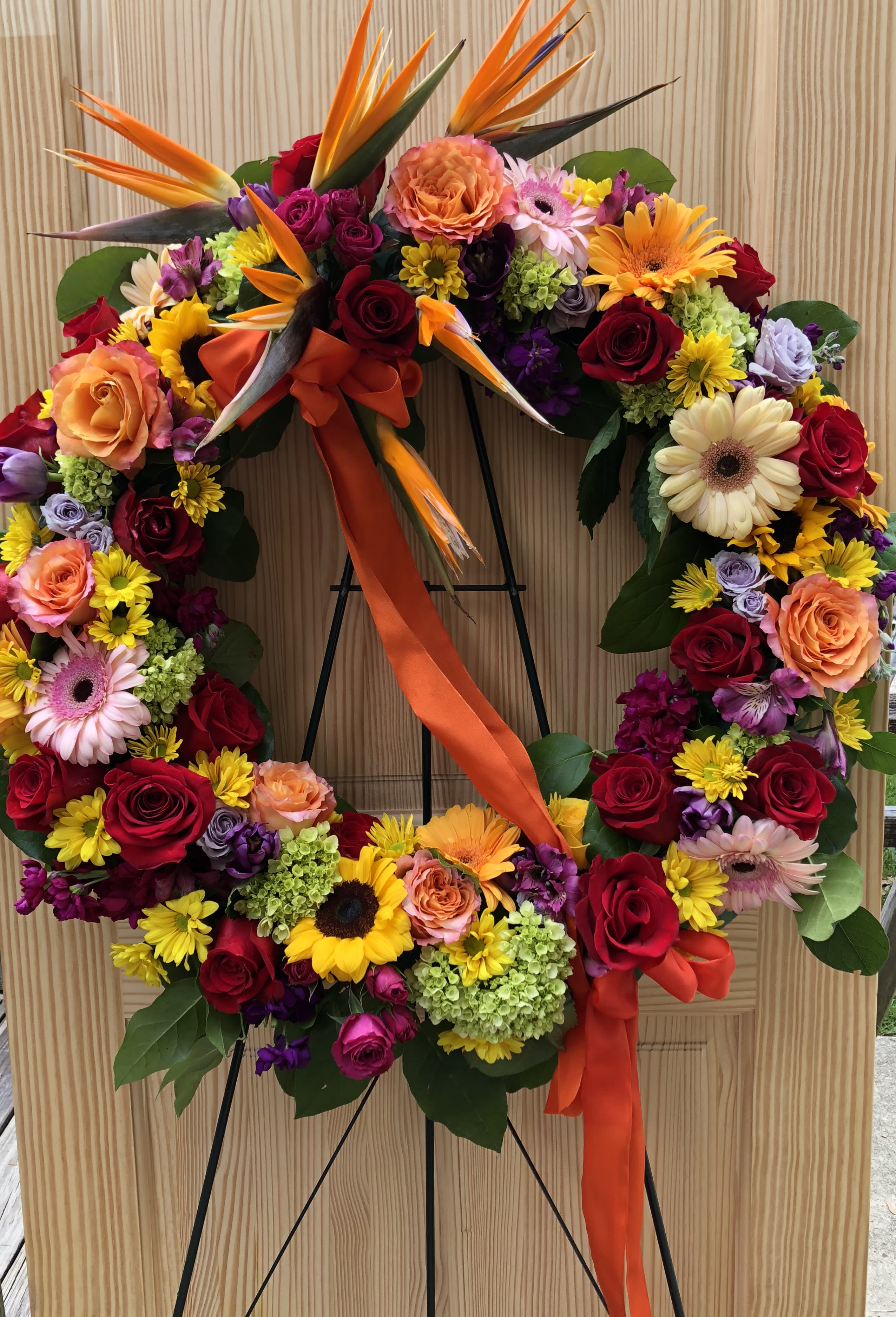 Large floral wreath with roses, gerbera daisies, and bird-of-paradise flowers