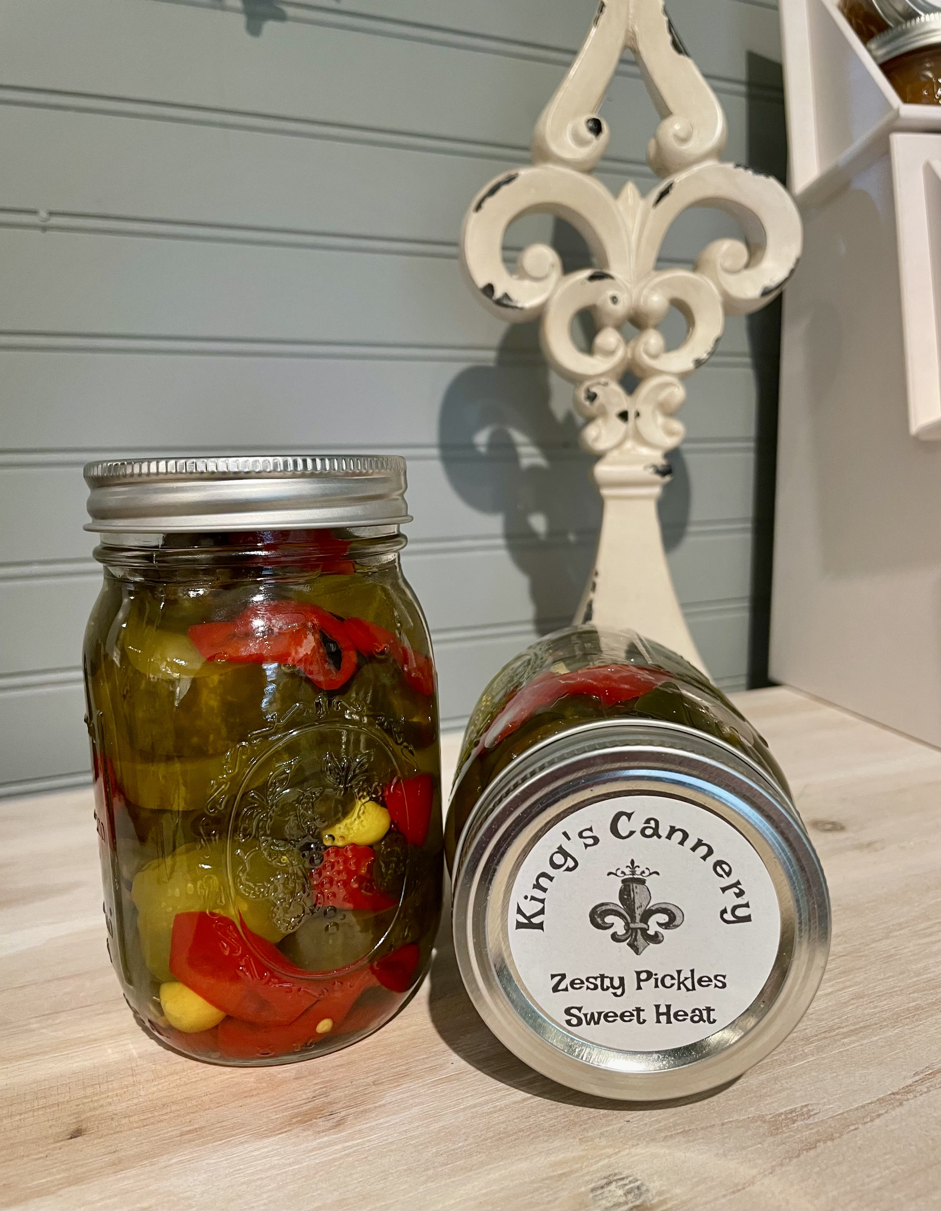 Two jars of pickles on a countertop, one upright and one lying on its side