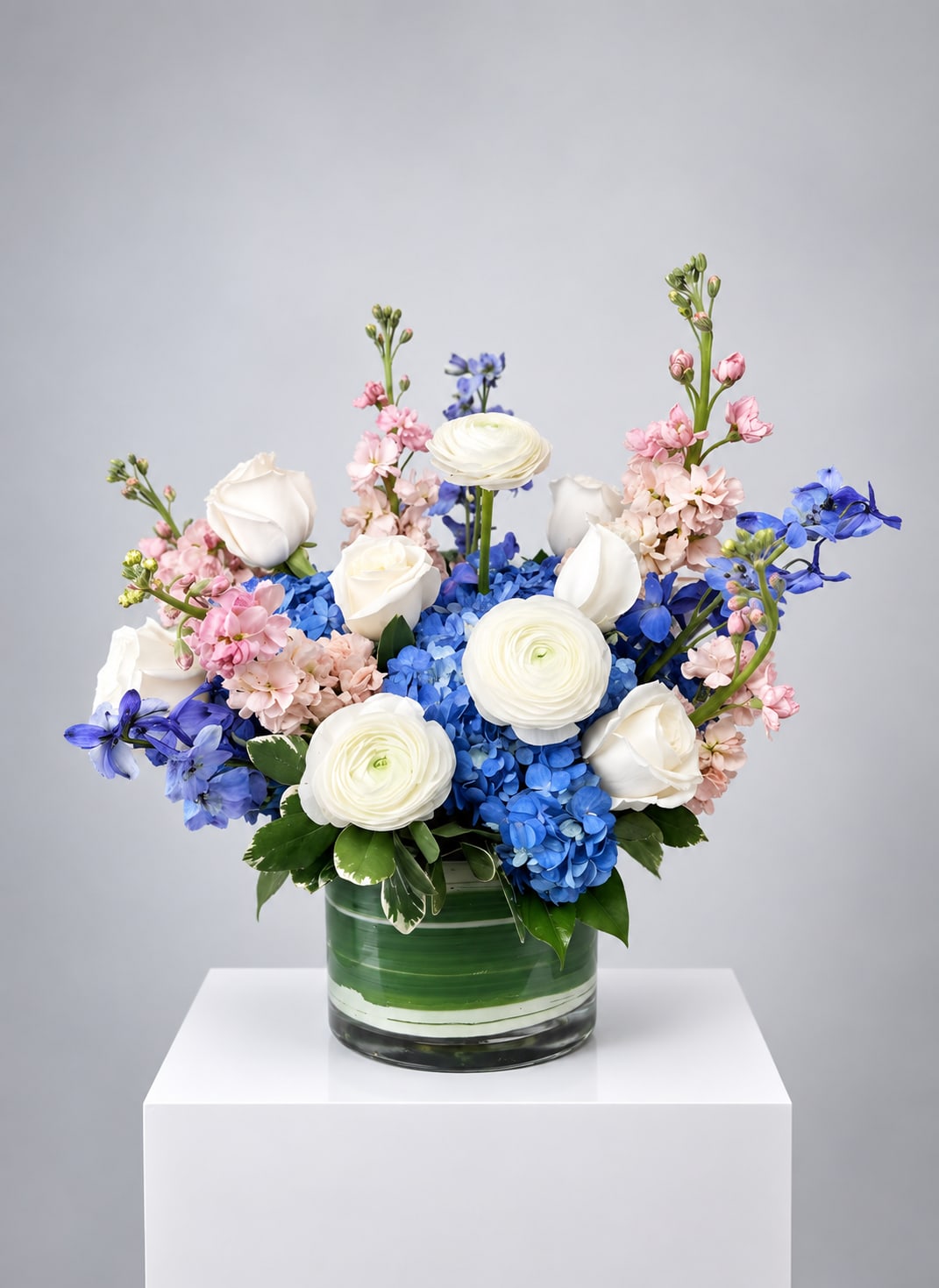 Blue and white floral arrangement in a glass vase