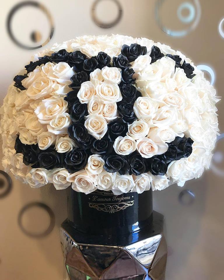 Black and white rose bouquet in a black vase