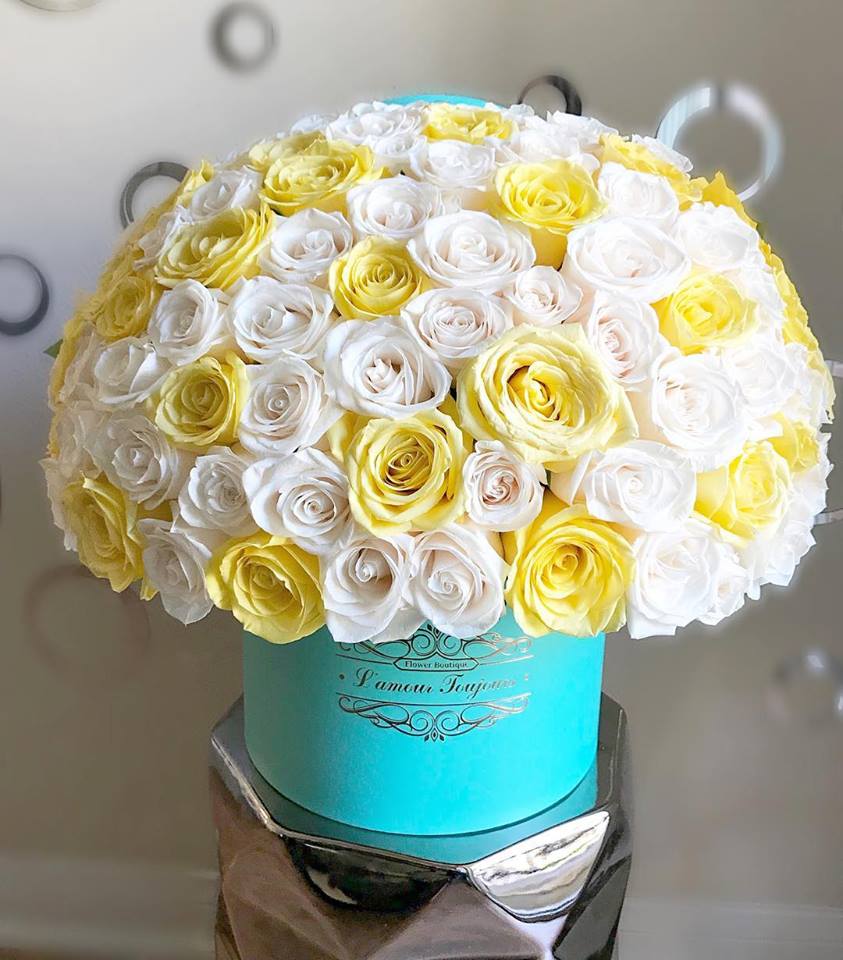 Bouquet of white and yellow roses in a turquoise hat box