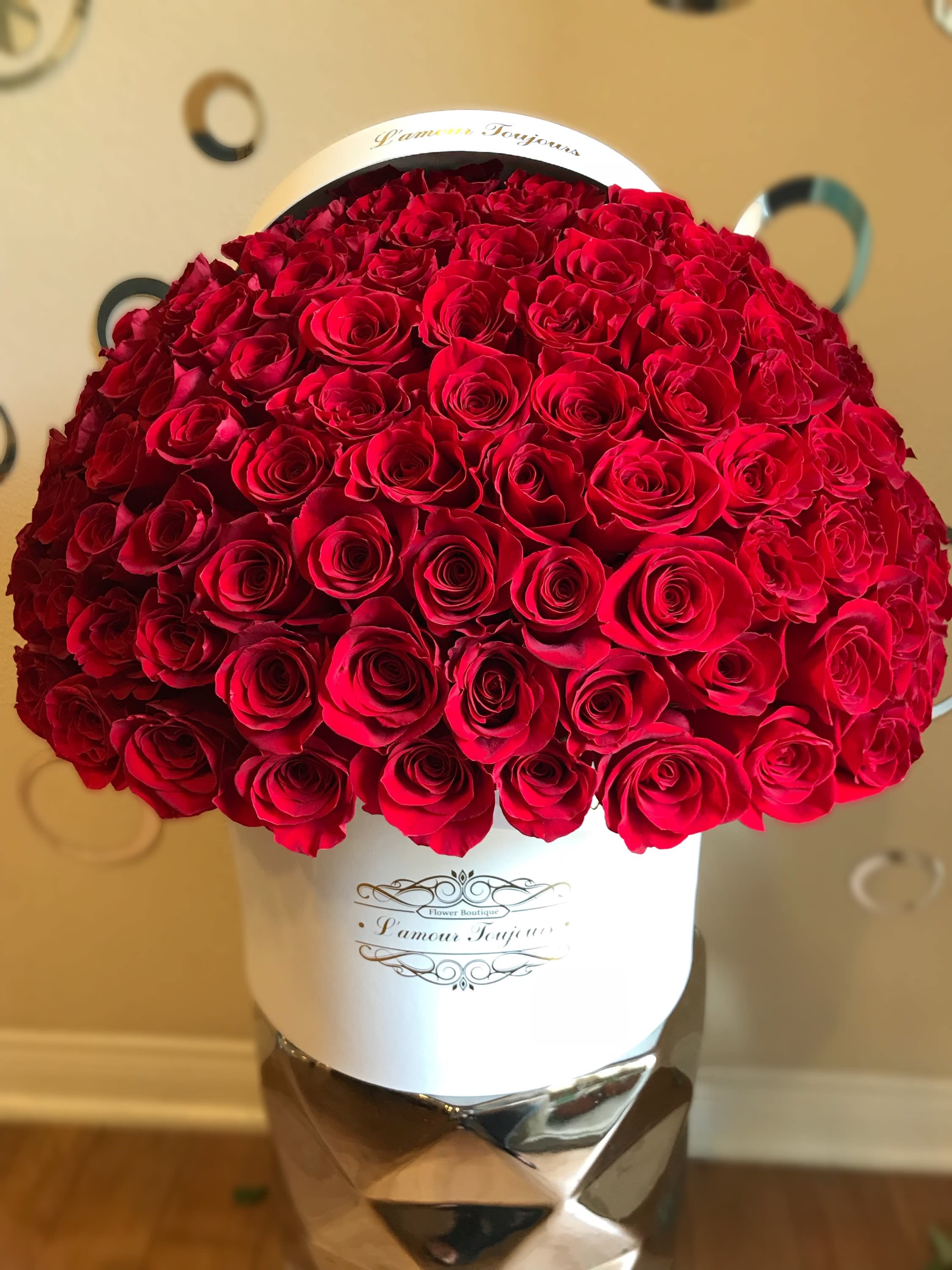 Large dome of red roses arranged tightly in a white hatbox container