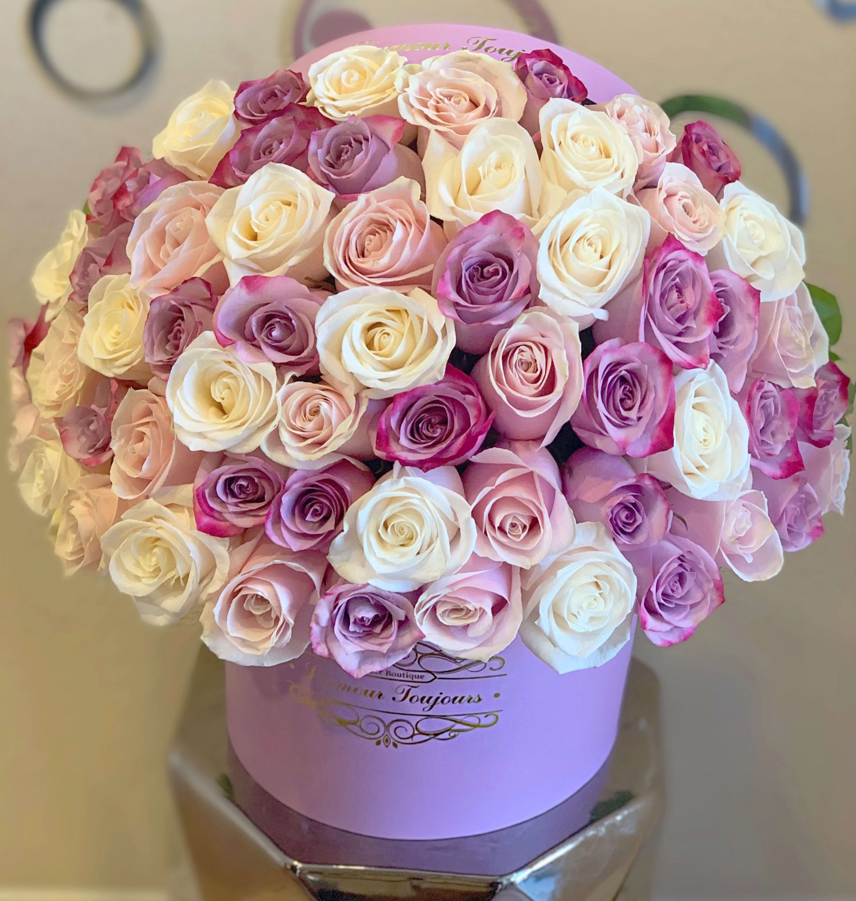 Bouquet of pink, white, and lavender roses in a lavender hat box