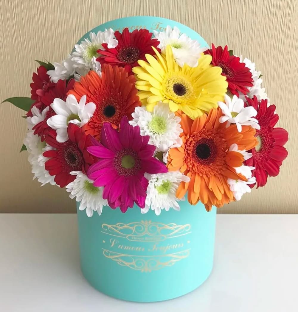 Colorful gerbera daisy bouquet in a turquoise hat box